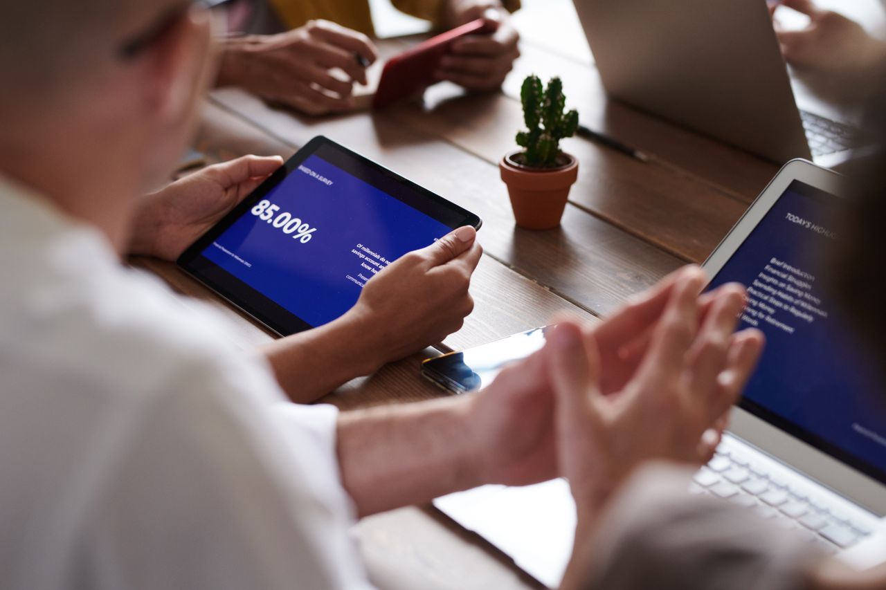 Business meeting with tablets and laptops. Focus on presentation on tablet screen.